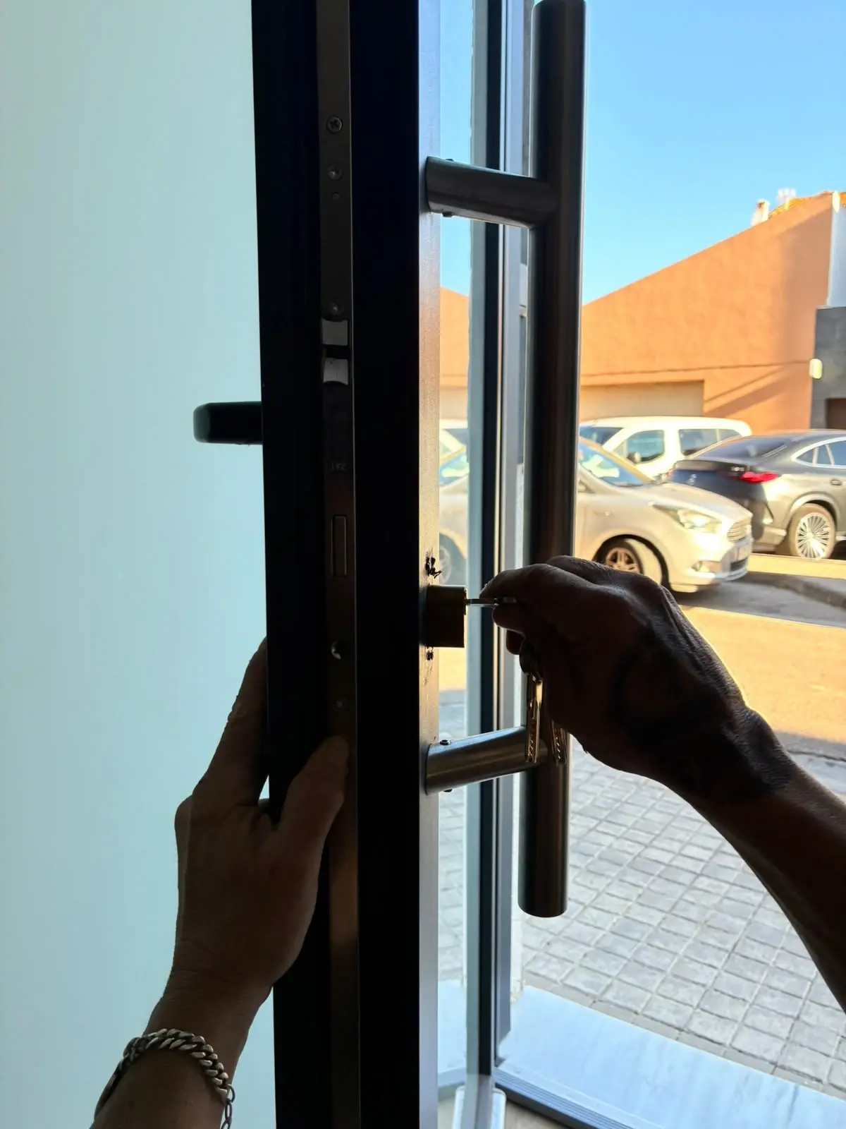 Professional treballant en el bombí d'una porta metàl·lica de vidre